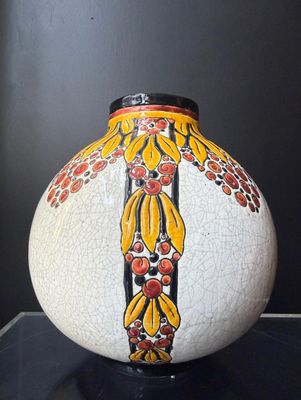 un vase blanc orné d'un motif jaune et rouge