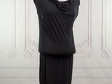 black dress on a mannequin stand in a white room