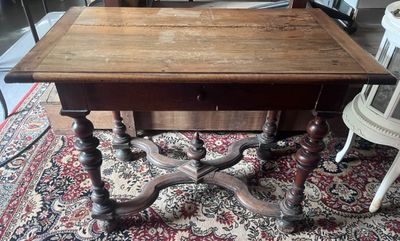 une table avec un plateau en bois posée sur un tapis dans une pièce