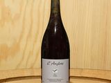 une bouteille de vin posée sur un tonneau en bois
