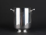 an antique silverplated ice bucket with handles on a black background