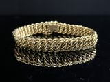 gros plan d'un bracelet en or sur une surface noire