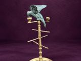 un oiseau sur une plaque en laiton avec un fond violet