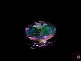 un gros plan d'un diamant coloré sur une surface noire