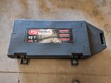 a small tool box on the floor with a person standing next to it