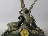 bronze statue of a woman and a winged man on a clock