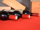 several bottles of wine are lined up on a red table