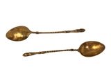 pair of antique brass spoons on a white background