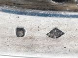a close up of a silver plate with a bird on it