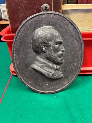 une image représentant un médaillon en bronze à l'effigie d'un homme