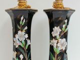 deux vases avec des fleurs peintes dessus, posés sur une table