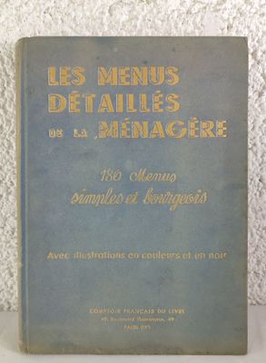 un vieux livre posé sur une table à côté d'un mur blanc
