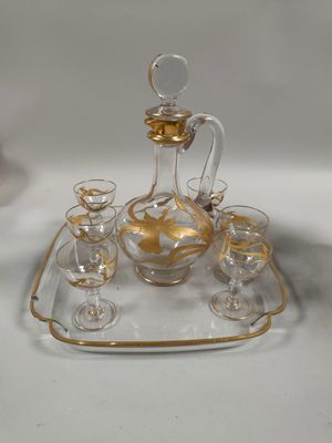 des bouteilles et des verres posés sur un plateau, lui-même posé sur une table devant un miroir