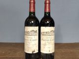 two bottles of wine sitting on top of a wooden table