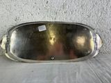 a silver plate sitting on a white surface with a tag on it