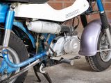 a blue and white motorcycle parked in front of a brick wall
