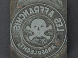 a metal plaque with a skull and crossbone on it