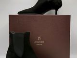 a pair of black sued ankle boots sitting on top of a box