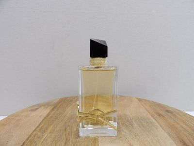 an image of a bottle of perfume sitting on top of a wooden table