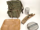 a backpack, a lunch box, and a can of soda sitting on a table