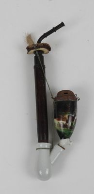 a pipe and a glass bottle on a white surface