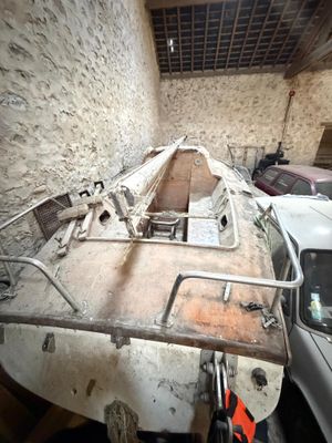 a boat that is sitting in a garage next to a car