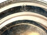 a silver plate that has a monogram on it