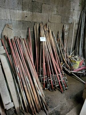 a pile of baseball bats sitting on the floor next to a wall