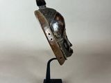 a close up of a metal sculpture of a helmet on a stand