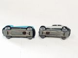 two toy cars sitting next to each other on a white surface