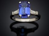 a blue sapphire and diamond ring on a black surface