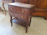 a small wooden table with two drawers on it