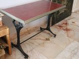 a small table with a red top sitting on a marble floor