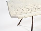 a white bench that is sitting on a metal stand