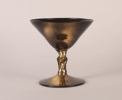 an image of a black and gold goblet sitting on top of a table