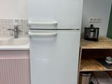 a white refrigerator sitting in a kitchen next to a sink