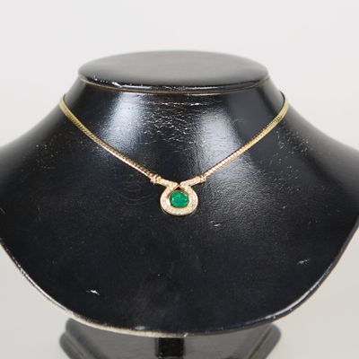 une photo d'un collier orné d'une pierre verte, porté par un mannequin