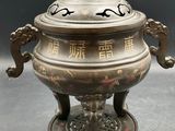 an antique silver plate with a bird on top of it
