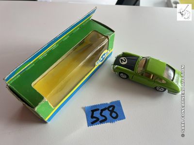une petite voiture verte posée à côté d'une boîte verte sur une table
