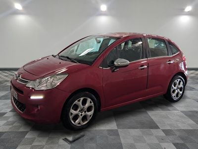 la voiture rouge est garée sur le sol en damier du garage