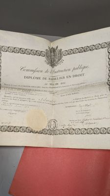 un vieux document sur lequel figure la photo d'un homme qui le tient