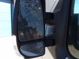 a side view mirror of a car with a reflection of a building in the side view mirror