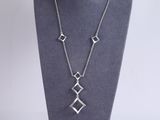 a silver necklace with three squares on a mannequin neck