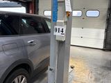 une voiture garée dans un garage équipé d'un pont élévateur