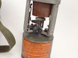 a small gas can with a strap on it next to a pair of shoes
