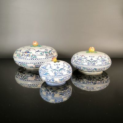 three blue and white dishes sitting on a black table