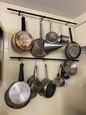 pots and pans hanging on a wall in a kitchen