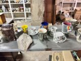 many cups and mugs sitting on a table in a room