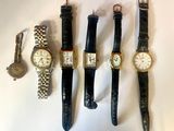 plusieurs types de montres sont alignés sur une surface blanche