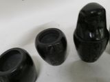 three black vases sitting next to each other on a table